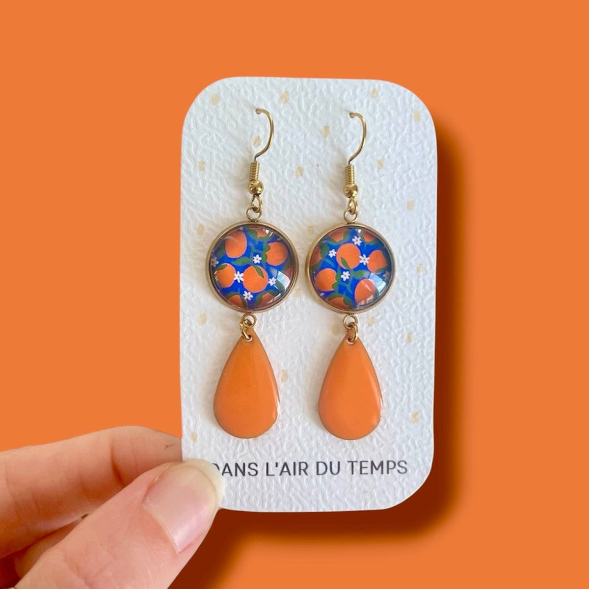 Boucles d'oreilles oranges sur fond bleu